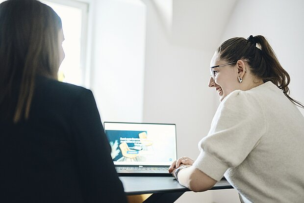 Kolleginnen bei der Zusammenarbeit am Laptop